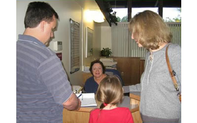 Katie and her parents being greeted by a DCC staff person at the front desk.